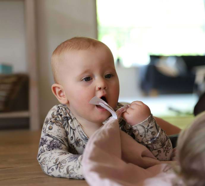 Baby på gulvet med en sutteklud