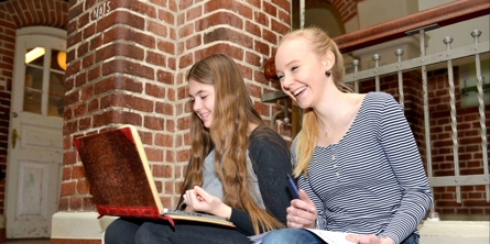 To skolepiger på trappen indenfor