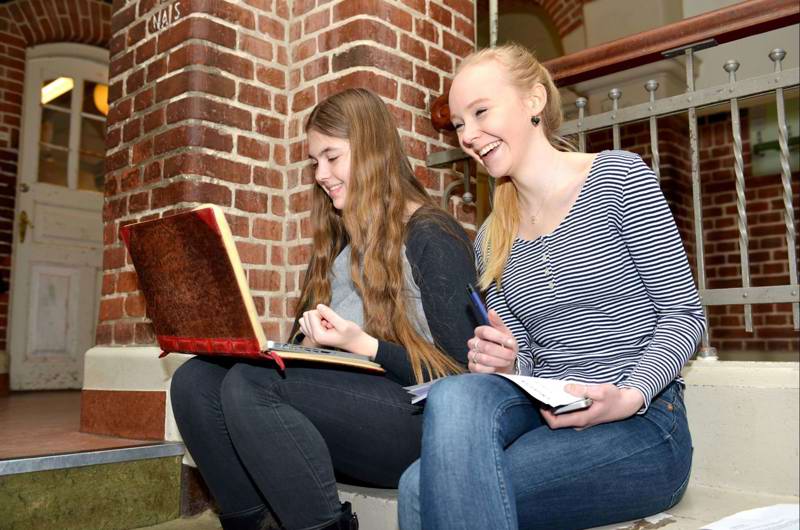 To skolepiger på trappen indenfor